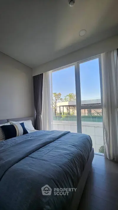 Modern bedroom with large window and elegant blue bedding