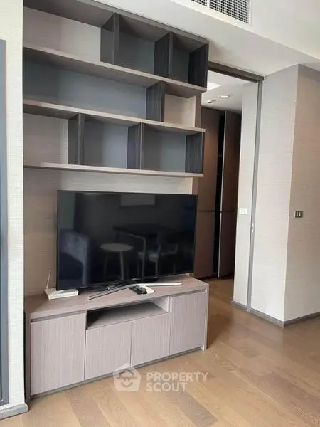 Modern living room with sleek TV stand and open shelving, perfect for stylish urban living.