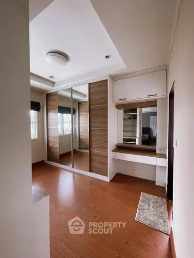 Spacious bedroom with wooden flooring and built-in wardrobe