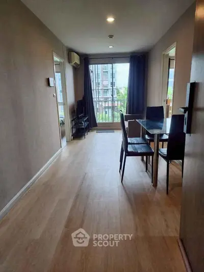 Spacious living room with dining area and balcony view in modern apartment.