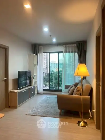 Modern living room with cozy sofa, TV, and balcony view in urban apartment.