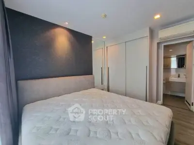 Spacious bedroom with modern design and ensuite bathroom in luxury apartment.
