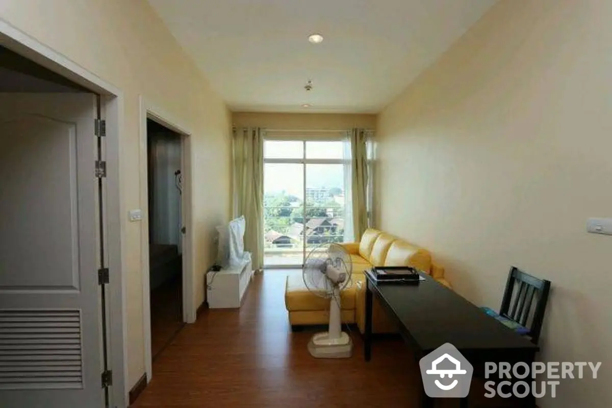 Cozy living room with yellow sofa and city view through large window