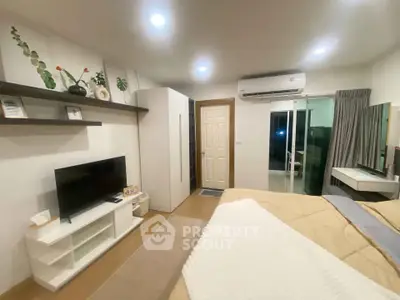Modern bedroom with TV, air conditioning, and balcony access in stylish apartment.