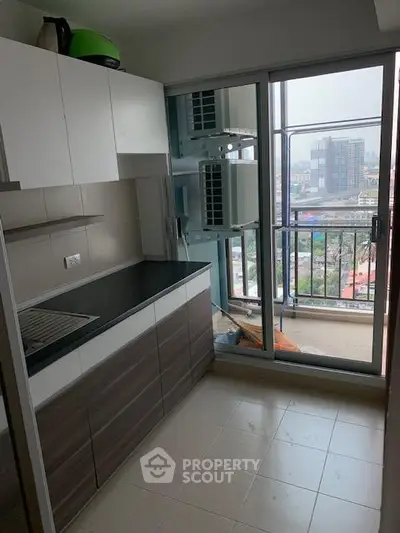 Modern kitchen with sleek cabinetry and city view from balcony