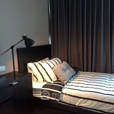 Cozy modern bedroom with stylish striped bedding and elegant lighting