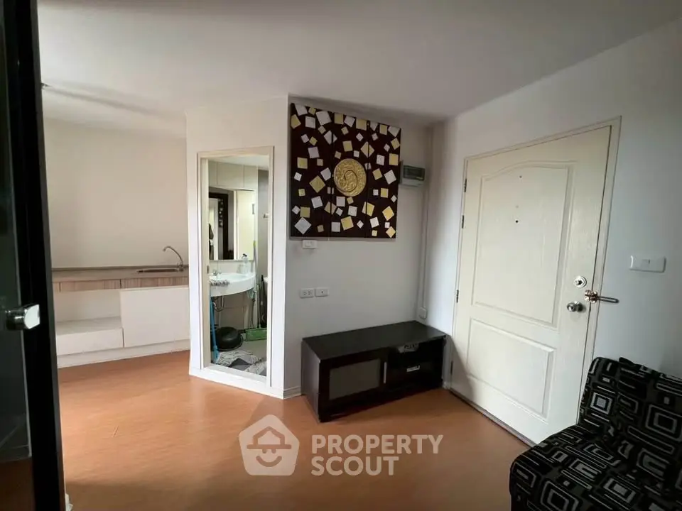 Modern apartment entrance with stylish decor and compact kitchen area.