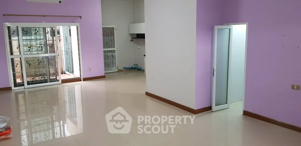 Spacious empty living room with purple walls and large windows, ideal for customization.