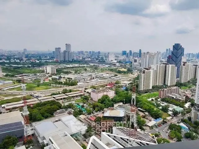 Stunning cityscape view from high-rise building showcasing urban skyline and lush greenery.