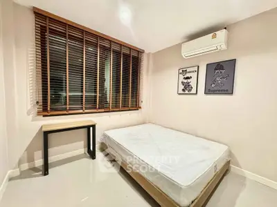 Modern bedroom with minimalist decor, featuring a comfortable bed and stylish window blinds.