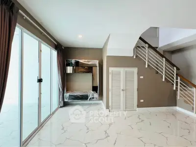 Modern living room with marble flooring and staircase, featuring large windows and stylish design.