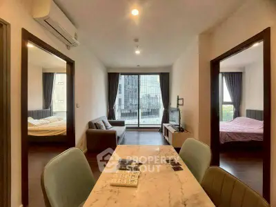 Modern apartment interior with two bedrooms, stylish living area, and city view from large window.