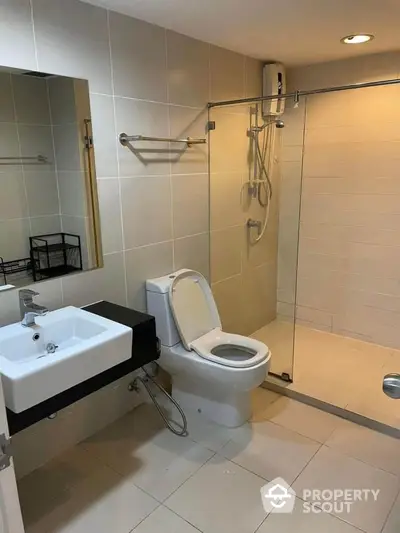 Modern bathroom with glass shower and sleek fixtures in contemporary apartment.