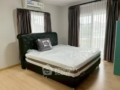 Spacious bedroom with elegant decor and large windows for natural light.