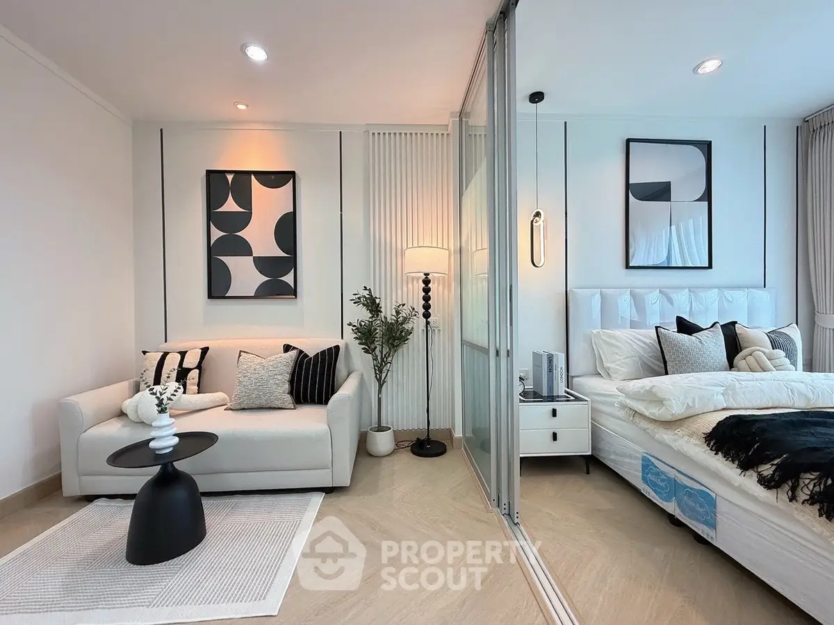 Modern bedroom with stylish decor and cozy seating area, featuring elegant wall art and soft lighting.