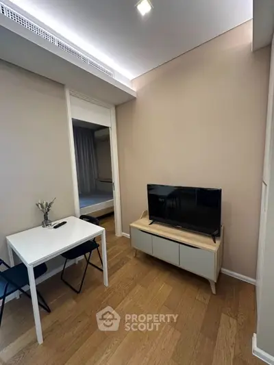 Modern compact living room with TV and dining table, wooden flooring