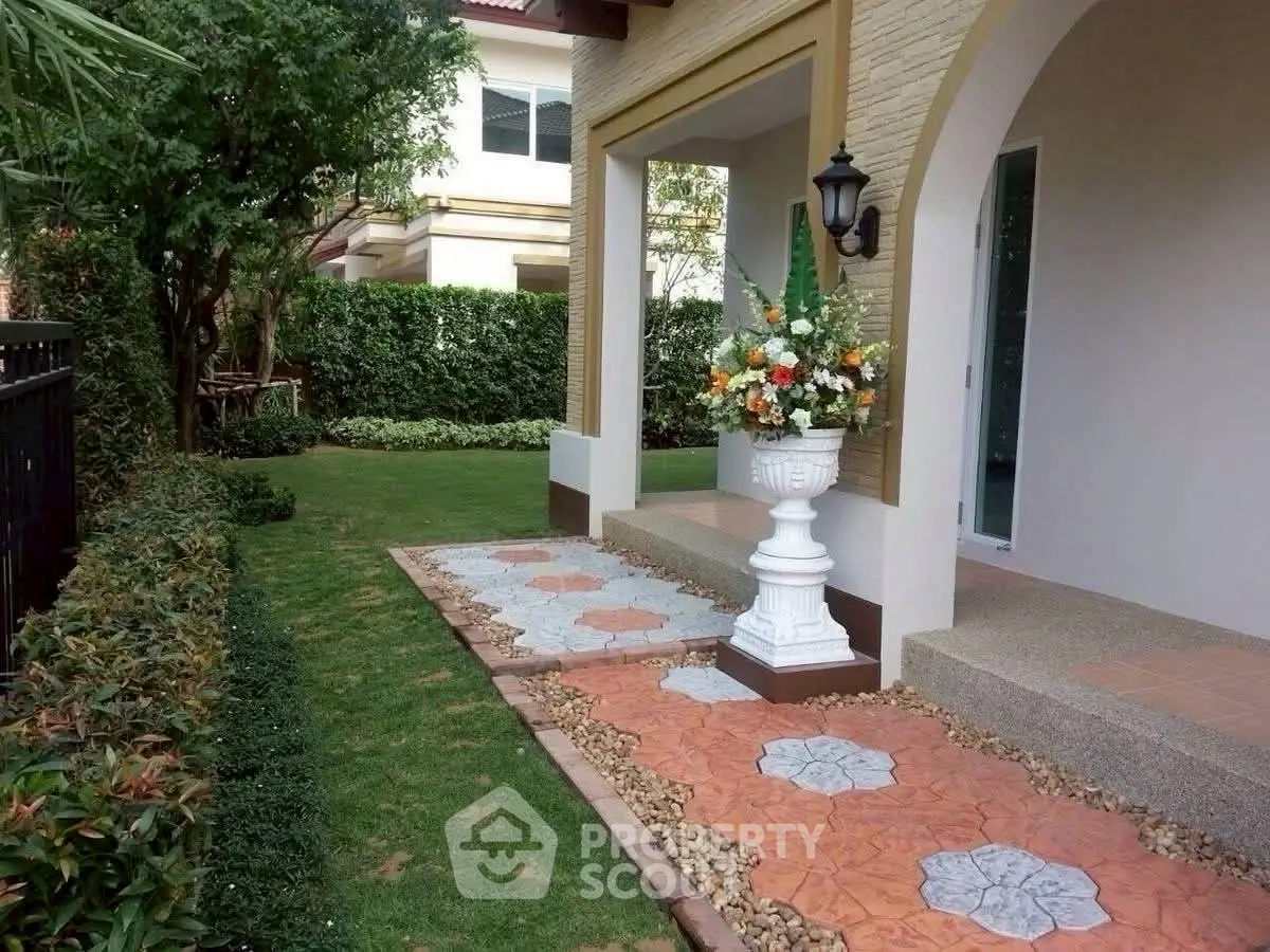 Charming garden entrance with elegant pathway and lush greenery