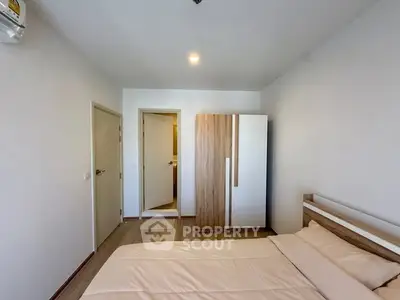 Modern bedroom with minimalist design and wooden wardrobe in a cozy apartment.