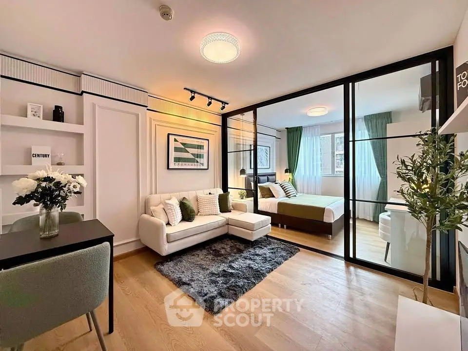 Modern open-plan living room with stylish decor and cozy bedroom area