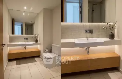 Modern bathroom with sleek design, featuring a large mirror, elegant sink, and stylish lighting.