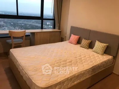 Modern bedroom with large window offering stunning city view, featuring cozy bed and stylish decor.