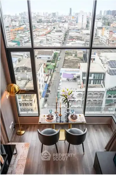Stunning high-rise apartment with floor-to-ceiling windows offering panoramic city views and elegant dining setup.