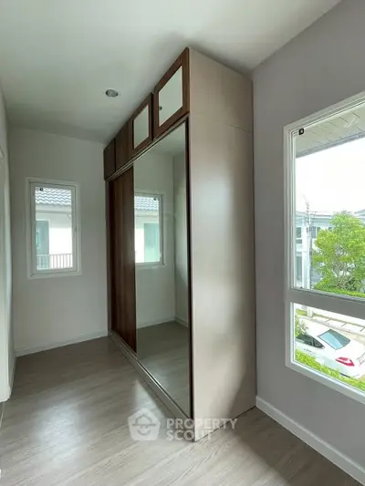 Spacious room with large mirrored wardrobe and bright windows