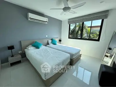 Modern bedroom with twin beds, air conditioning, and large window with garden view.