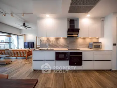 Modern open kitchen with sleek cabinetry and integrated appliances in a stylish apartment.