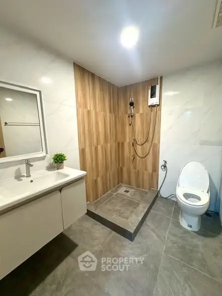 Modern bathroom with sleek design, featuring a spacious shower and elegant fixtures.