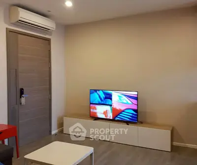 Modern living room with sleek TV setup and air conditioning, perfect for relaxation.