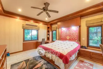 Spacious bedroom with elegant wooden decor and ceiling fan