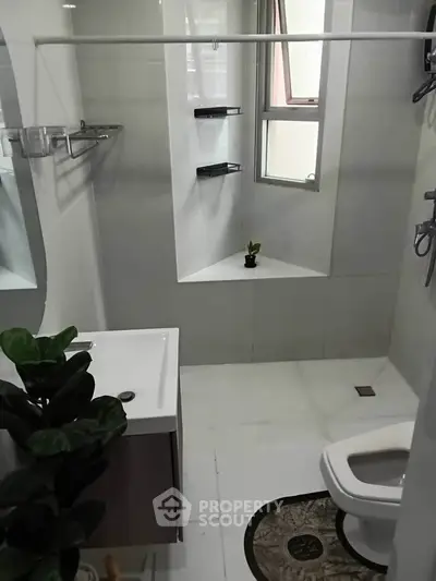 Modern bathroom with sleek fixtures and a small window for natural light.