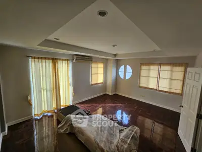 Spacious living room with hardwood floors and natural light