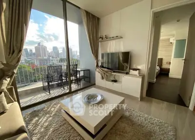 Modern living room with city view, stylish furniture, and balcony access in a high-rise apartment.