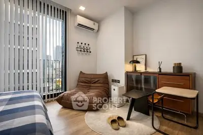 Cozy modern bedroom with city view, featuring stylish furniture and natural light.