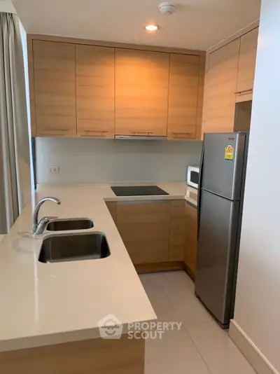 Modern kitchen with sleek wooden cabinetry, stainless steel appliances, and a spacious countertop perfect for culinary enthusiasts.