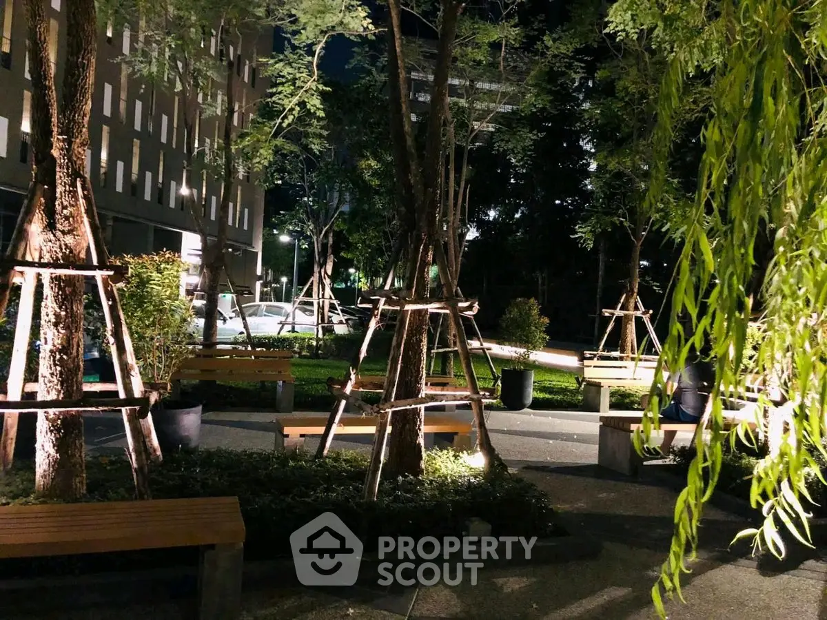 Charming night view of a landscaped garden with benches and trees, perfect for relaxation.
