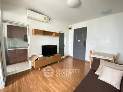 Modern living room with wooden flooring and sleek furniture in cozy apartment.