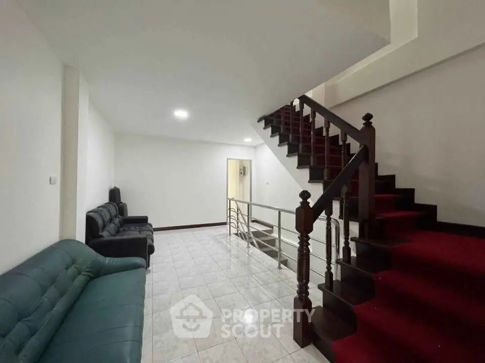Spacious living area with elegant staircase and comfortable seating