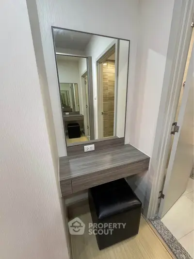 Modern vanity area with sleek mirror and stool in stylish apartment