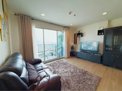 Spacious living room with leather sofa and balcony view in modern apartment