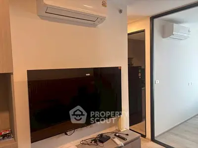 Modern living room with wall-mounted TV and air conditioning in a stylish apartment.