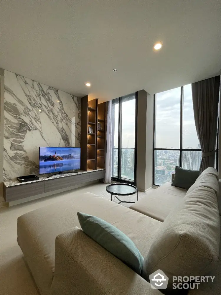 Luxurious high-rise living room with marble wall accent, plush sofa, and panoramic city views through floor-to-ceiling windows, exuding modern elegance.