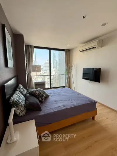 Modern bedroom with city view, featuring a cozy bed, wall-mounted TV, and air conditioning.