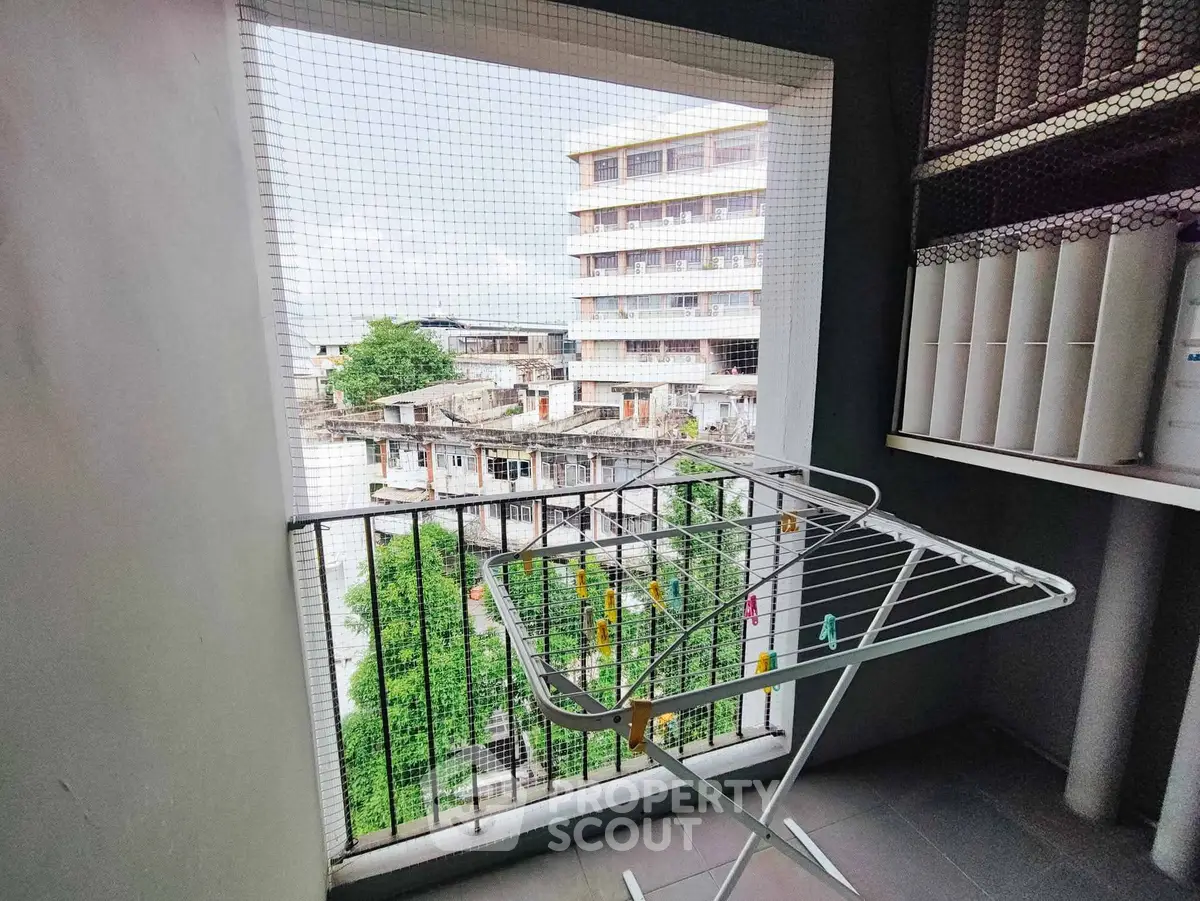 Urban balcony with drying rack and city view, ideal for compact living spaces.