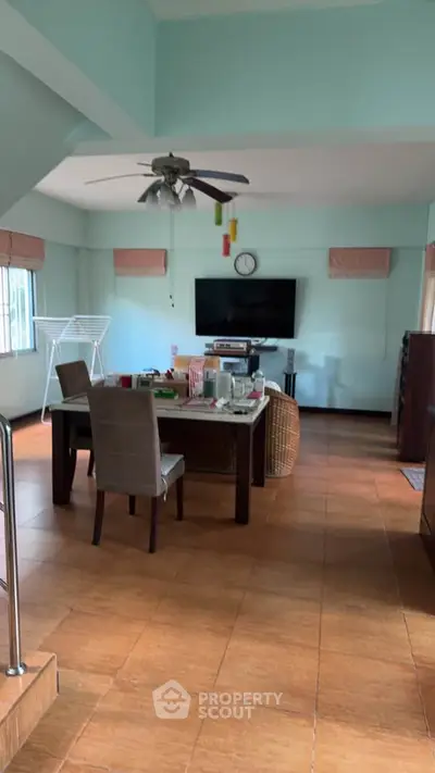 Spacious living room with modern decor and large TV, perfect for family gatherings.