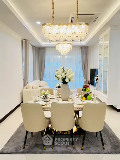 Luxurious dining room with elegant chandelier and modern decor in a spacious living area.