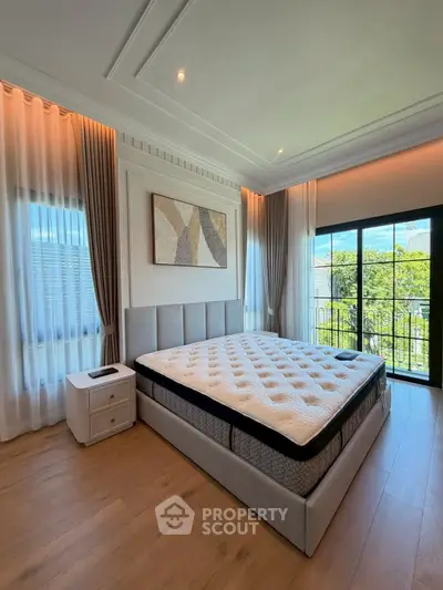 Luxurious bedroom with elegant decor and balcony view, featuring a plush bed and stylish curtains.