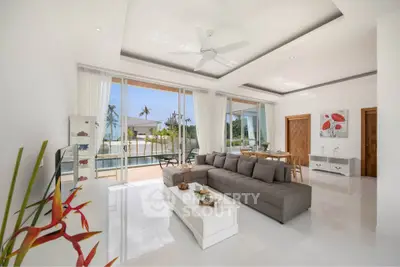 Spacious modern living room with large windows and pool view in luxury home